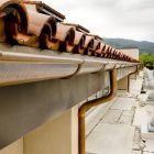 Close-up of a building rooftop with terracotta tiles and copper gutters.